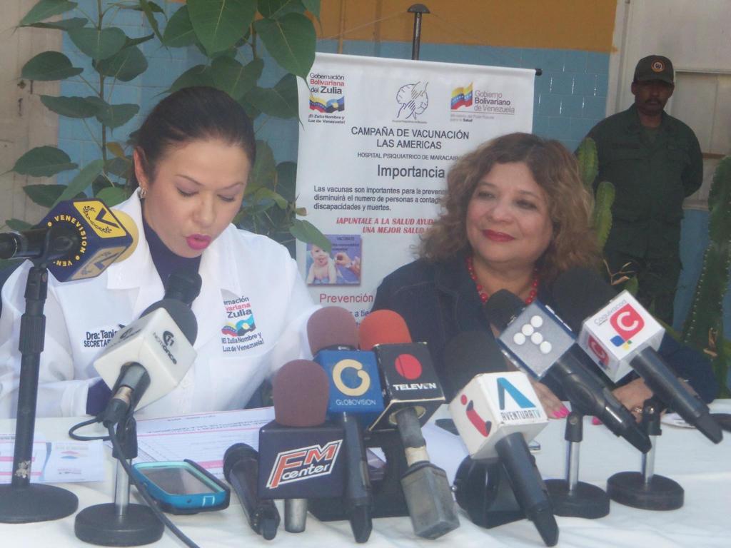 María Zavala en una rueda de prensa sobre una campaña de vacunación, rodeada de micrófonos