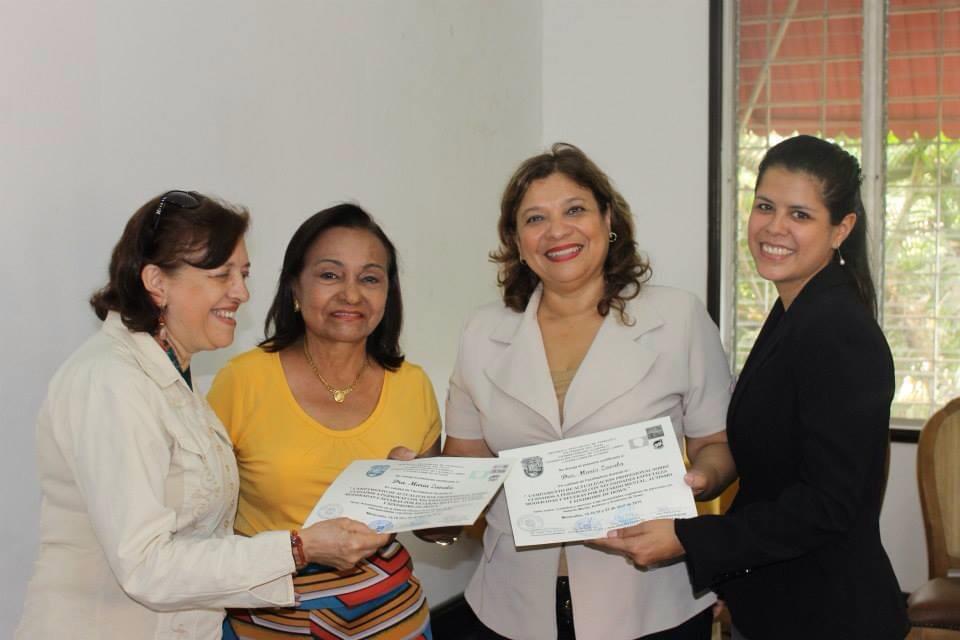 María Zavala recibiendo un certificado junto a otras tres profesionales
